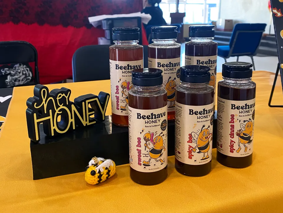Beehave Honey bottles on display next to a “her HONEY” sign